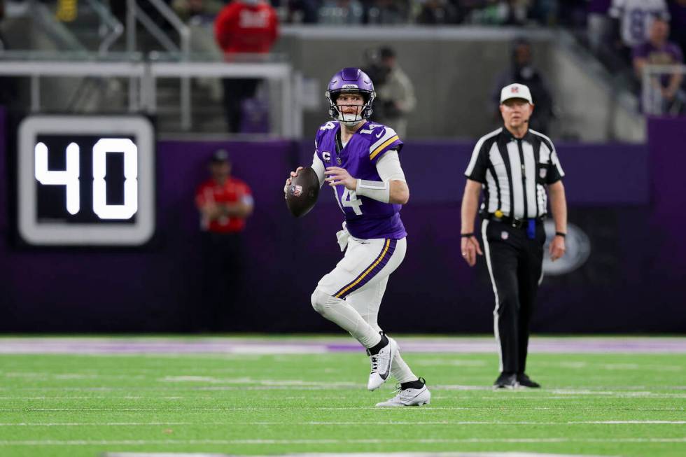 Minnesota Vikings quarterback Sam Darnold handles the ball during the second half of an NFL foo ...