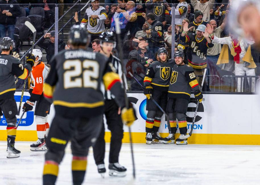 Golden Knights defenseman Noah Hanifin (15) and Golden Knights right wing Alexander Holtz (26) ...