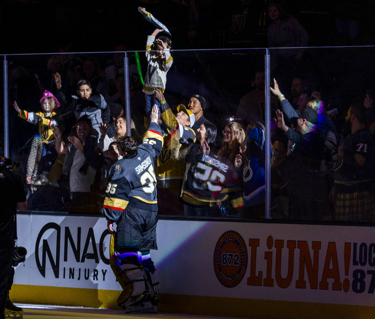 Golden Knights goaltender Ilya Samsonov (35) awards a toy sword to a fan as player of the game ...