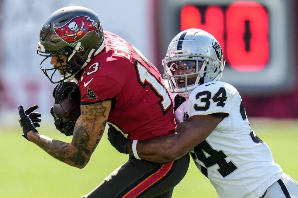 Tampa Bay Buccaneers wide receiver Mike Evans (13) is stopped by Las Vegas Raiders safety Thoma ...