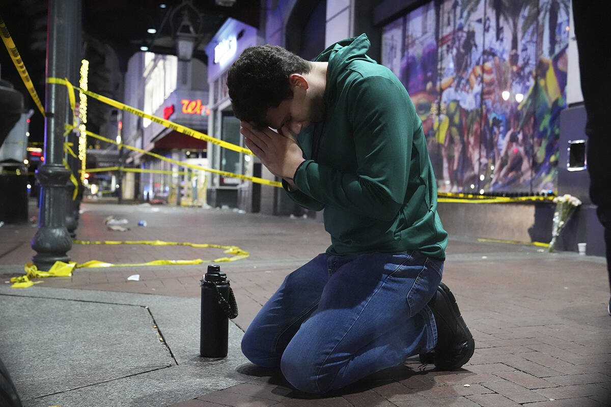 Matthias Hauswirth of New Orleans prays on the street near the scene where a vehicle drove into ...