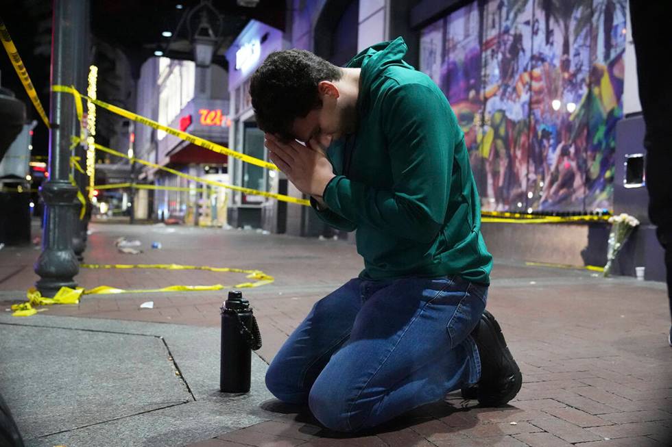 Matthias Hauswirth of New Orleans prays on the street near the scene where a vehicle drove into ...