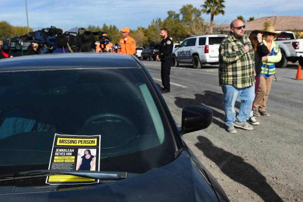 Corey and Jennifer Swanson are escorted past a missing person flyer for their daughter, Jennale ...