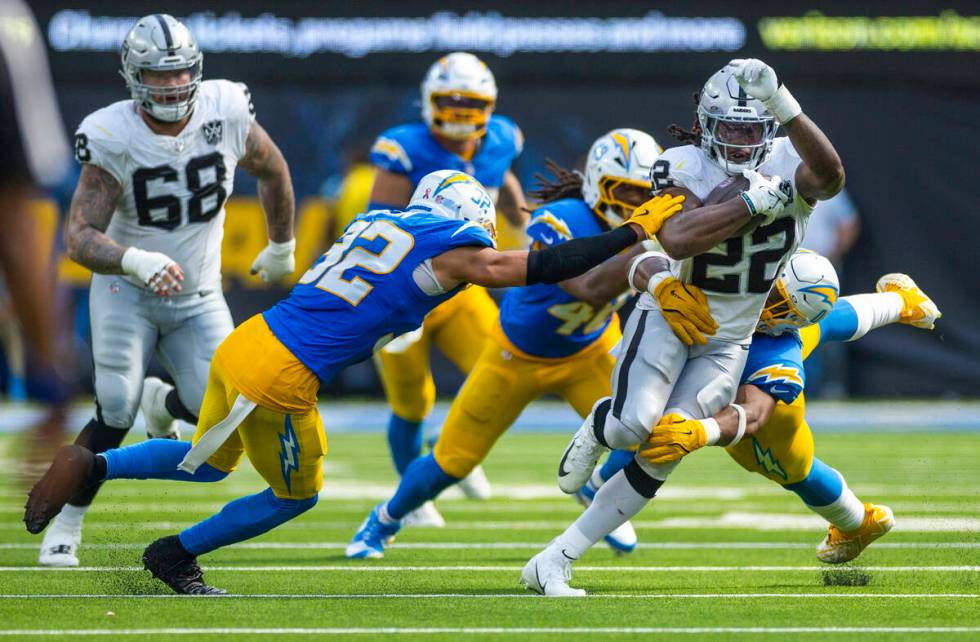 Raiders running back Alexander Mattison (22) is swarmed by Los Angeles Chargers defenders durin ...