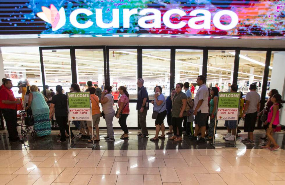 First shoppers are let in at the grand opening of electronics and appliance retailer Curacao at ...