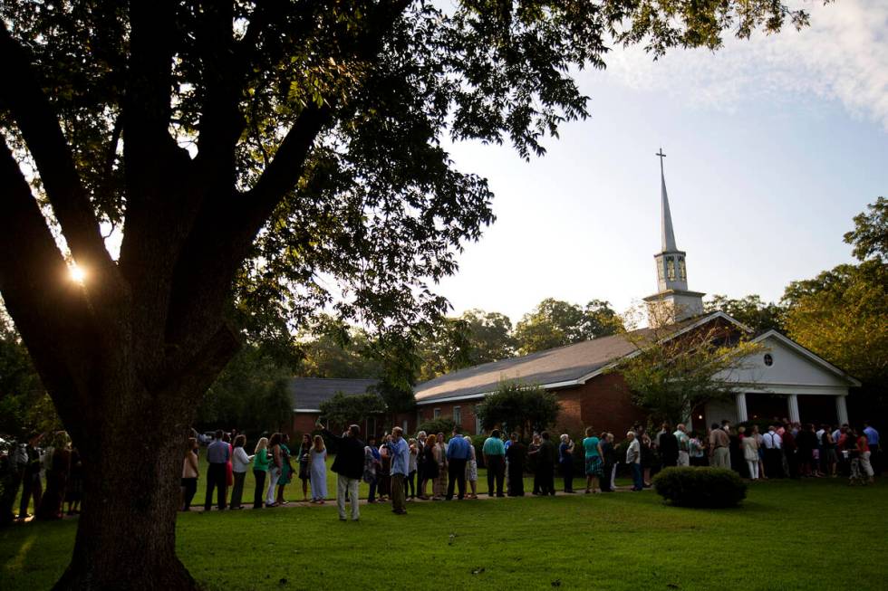 FILE - People wait in line outside Maranatha Baptist Church in Plains, Ga., to get into a Sunda ...