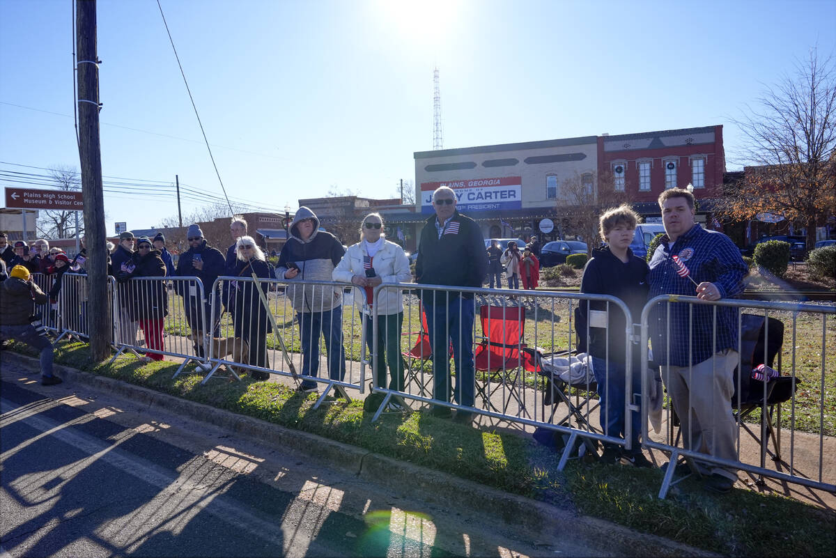 People line the street in Plains, Ga., before the hearse carrying the casket of former Presiden ...