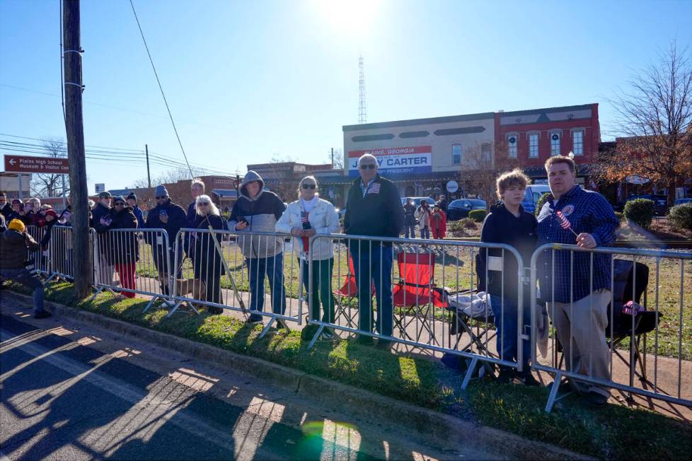 People line the street in Plains, Ga., before the hearse carrying the casket of former Presiden ...