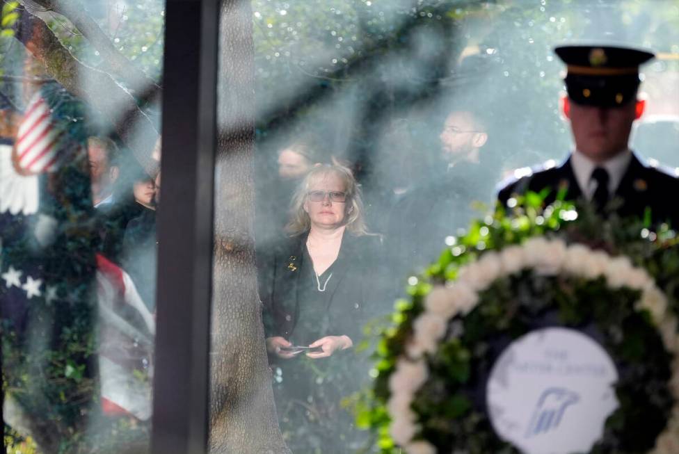 Amy Carter, reflected in a glass window, listens during a service for former President Jimmy Ca ...