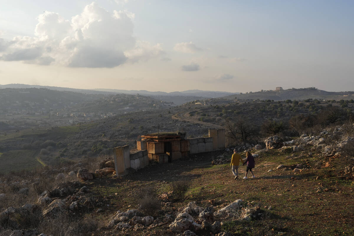 FILE - A couple walks to an Israeli army position near the Lebanese border on Dec. 5, 2024, in ...