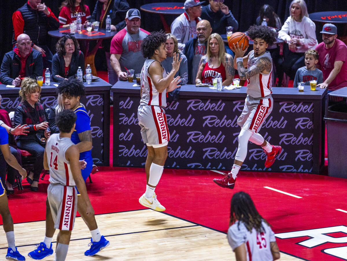 UNLV guard Luke Naser (3) grabs a rebound heading out of bounds and will pass it past forward J ...