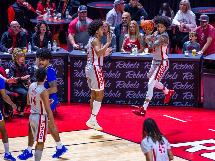 UNLV guard Luke Naser (3) grabs a rebound heading out of bounds and will pass it past forward J ...