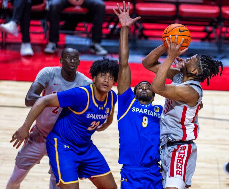 UNLV guard Jaden Henley (10) looks to shoot over San Jose State Spartans guard Josh Uduje (9) d ...