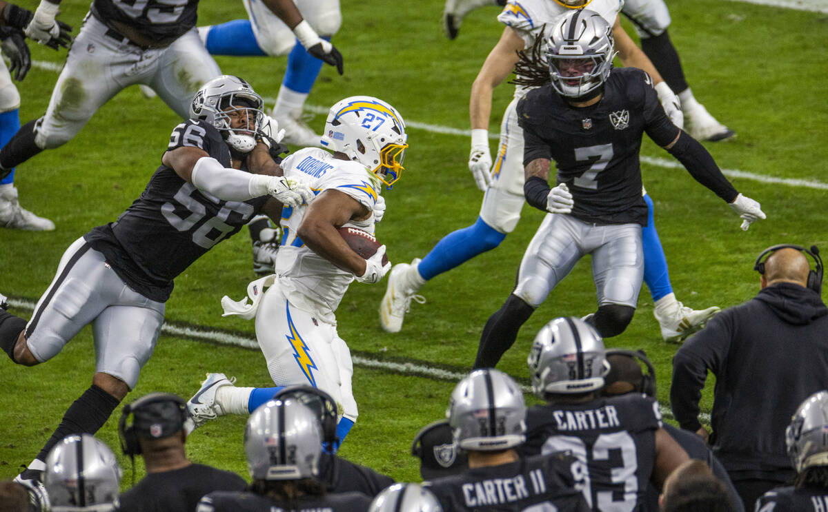 Raiders linebacker Amari Burney (56) tackles Los Angeles Chargers running back J.K. Dobbins (27 ...