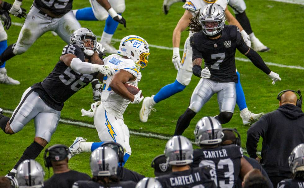 Raiders linebacker Amari Burney (56) tackles Los Angeles Chargers running back J.K. Dobbins (27 ...