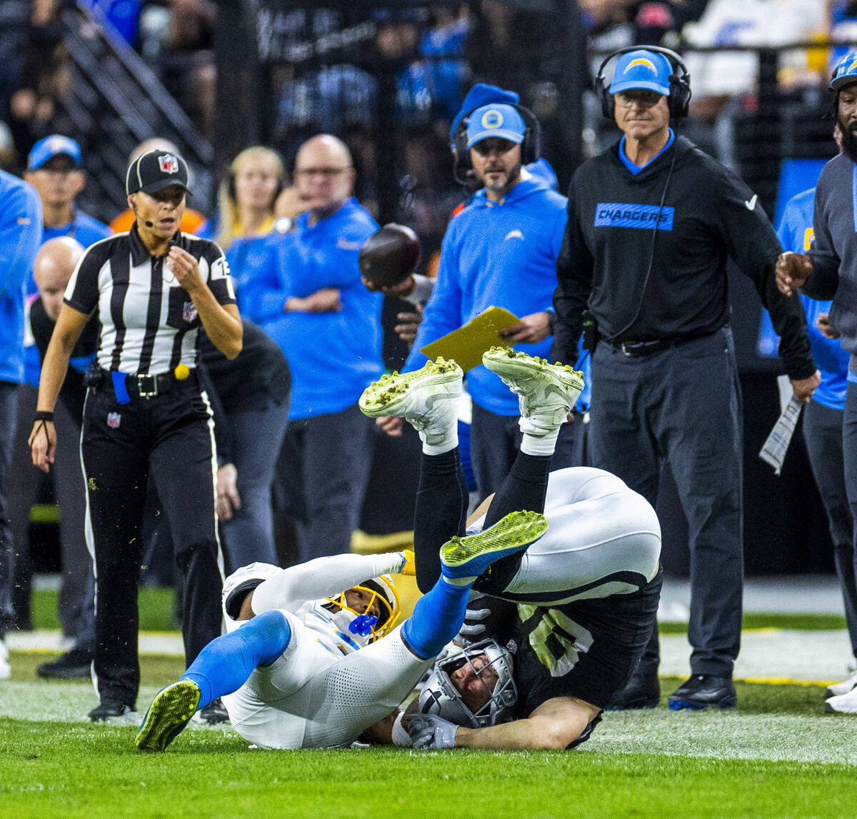 Raiders tight end Brock Bowers (89) is toppled on a tackle after a catch by Los Angeles Charger ...