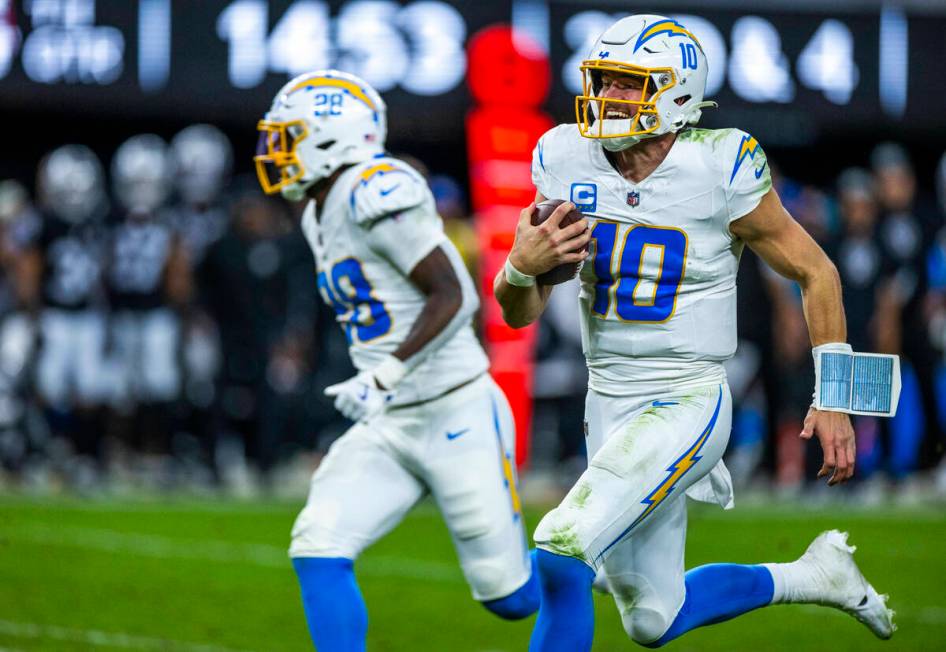 Los Angeles Chargers quarterback Justin Herbert (10) runs for open field against the Raiders du ...