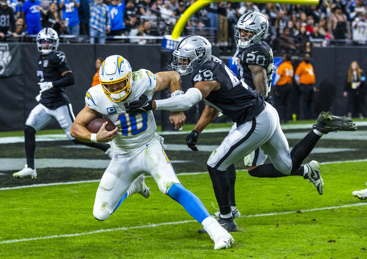 Los Angeles Chargers quarterback Justin Herbert (10) is finally caught after a run by Raiders d ...