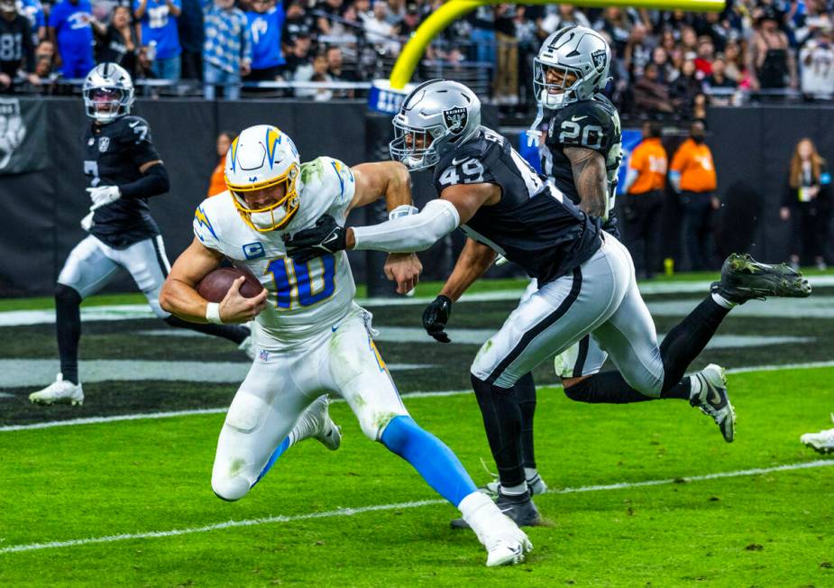 Los Angeles Chargers quarterback Justin Herbert (10) is finally caught after a run by Raiders d ...