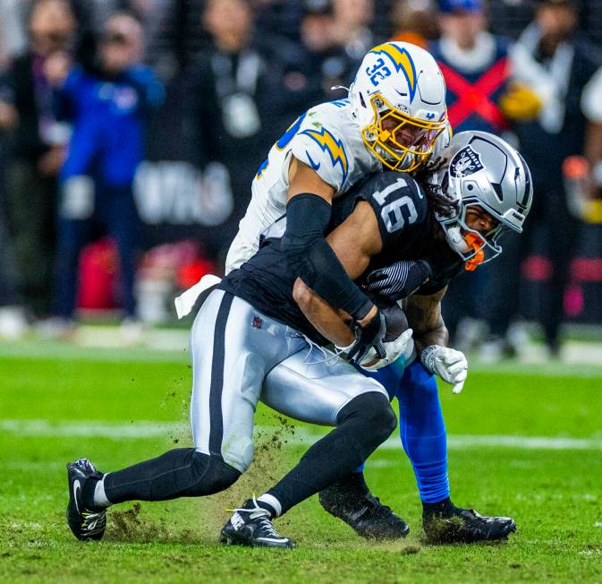 Raiders wide receiver Jakobi Meyers (16) is wrapped up after a catch by Los Angeles Chargers sa ...