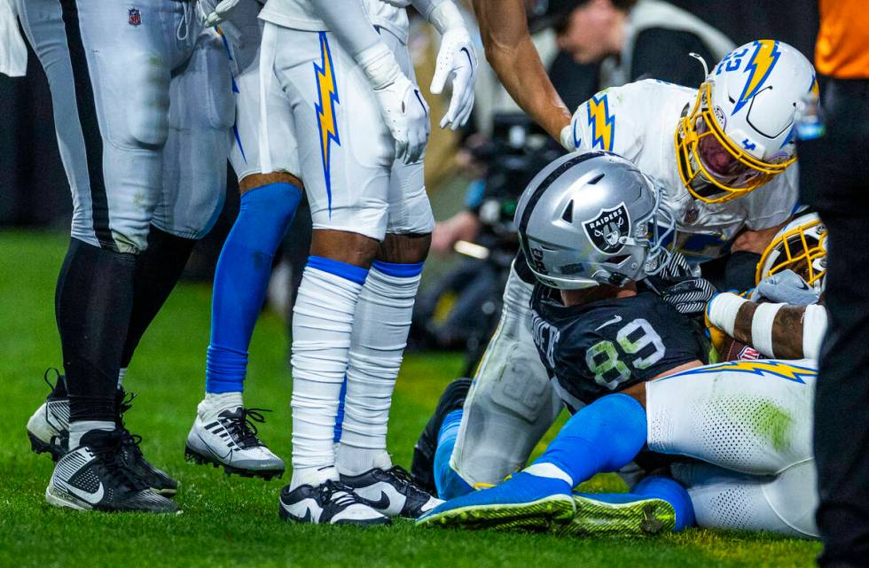 Raiders tight end Brock Bowers (89) continues to fight for the ball in the end zone with Los An ...