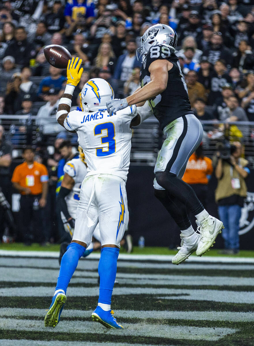 Raiders tight end Brock Bowers (89) and Los Angeles Chargers safety Derwin James Jr. (3) battle ...