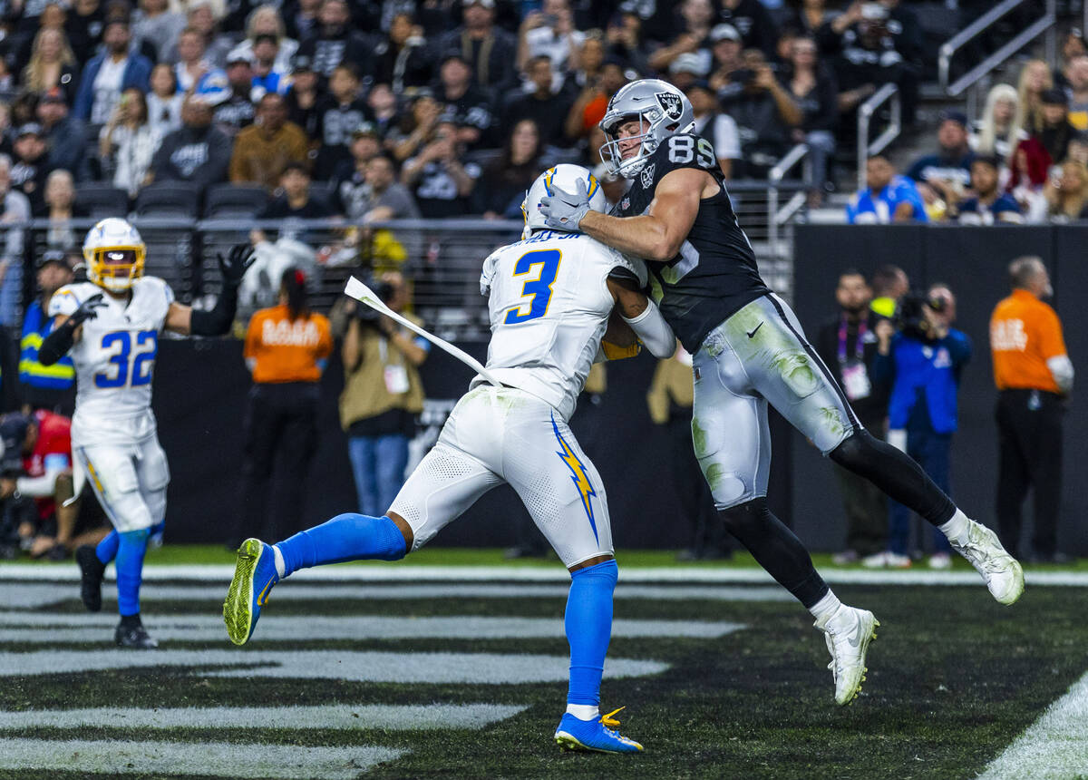 Raiders tight end Brock Bowers (89) and Los Angeles Chargers safety Derwin James Jr. (3) battle ...