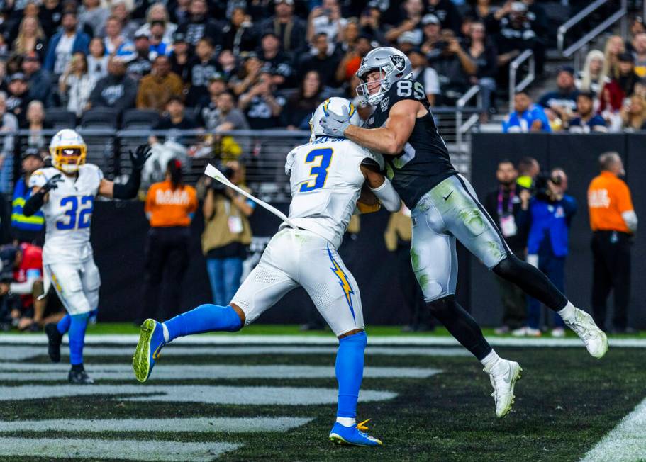 Raiders tight end Brock Bowers (89) and Los Angeles Chargers safety Derwin James Jr. (3) battle ...