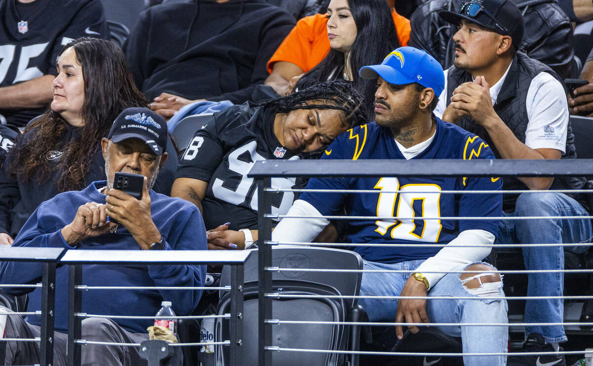 A Raiders fan rests her head on a Chargers fan during the second half of their NFL game at Alle ...