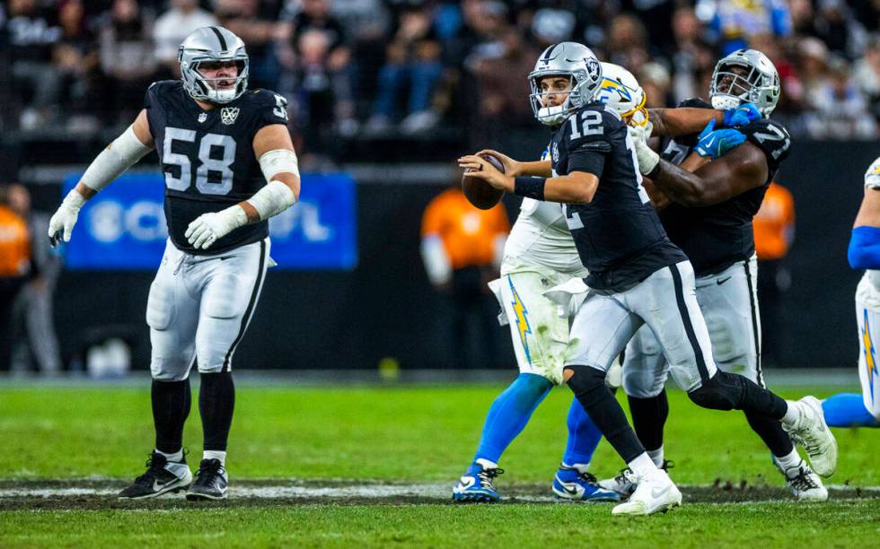 Raiders quarterback Aidan O'Connell (12) looks for a receiver against the Los Angeles Chargers ...