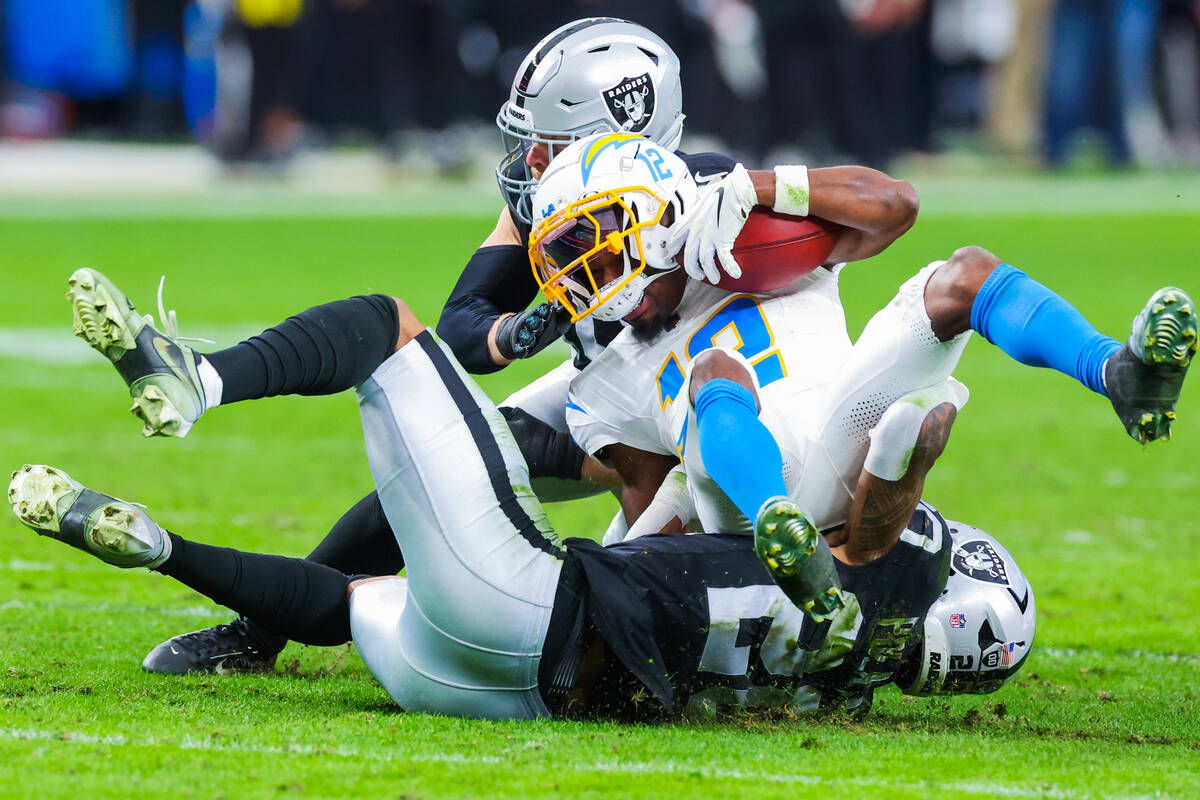 Los Angeles Chargers wide receiver Derius Davis (12) falls onto Raiders defense during an NFL f ...