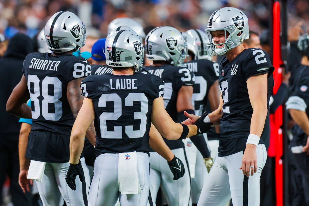 Raiders place kicker Daniel Carlson (2) high fives Raiders running back Dylan Laube (23) as he ...