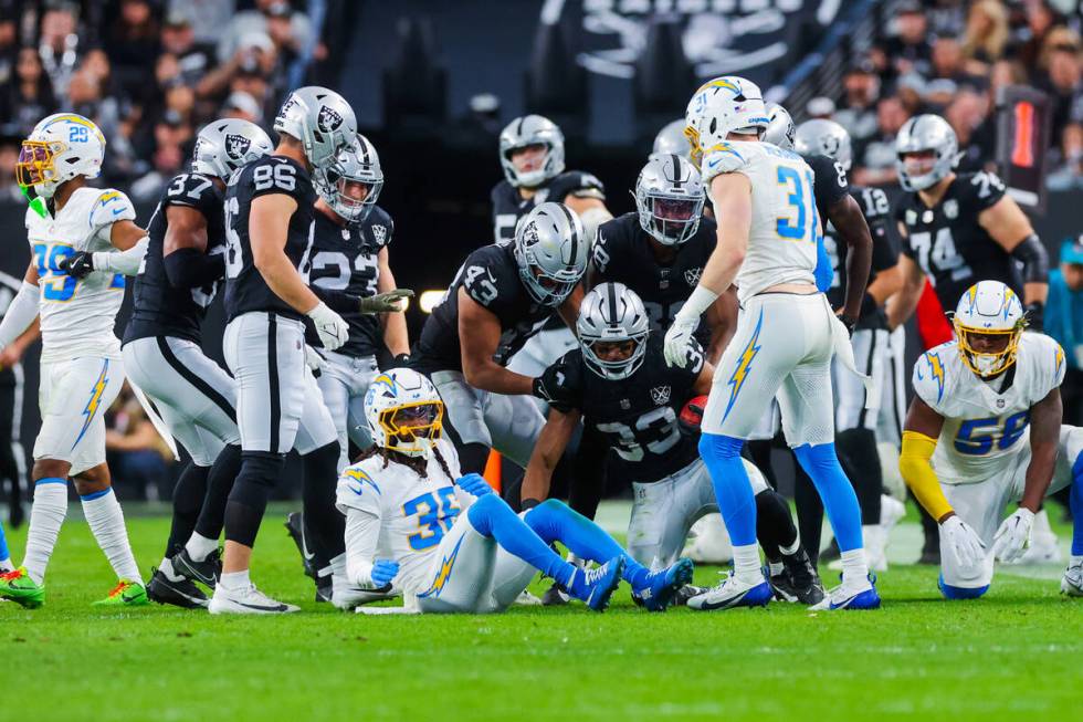 Raiders running back Chris Collier (33) gets up with the ball after a play during an NFL footba ...