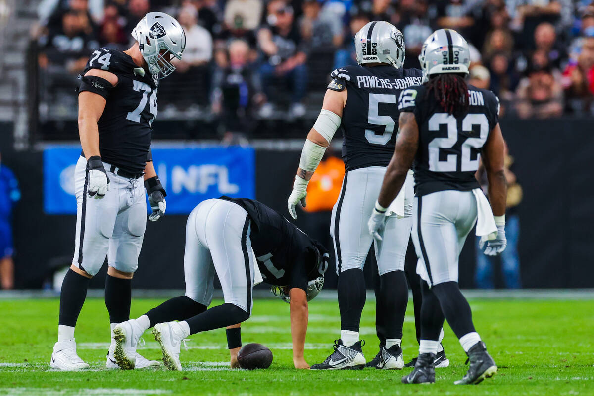 Raiders quarterback Aidan O'Connell (12) tries to get up after an injury during an NFL football ...