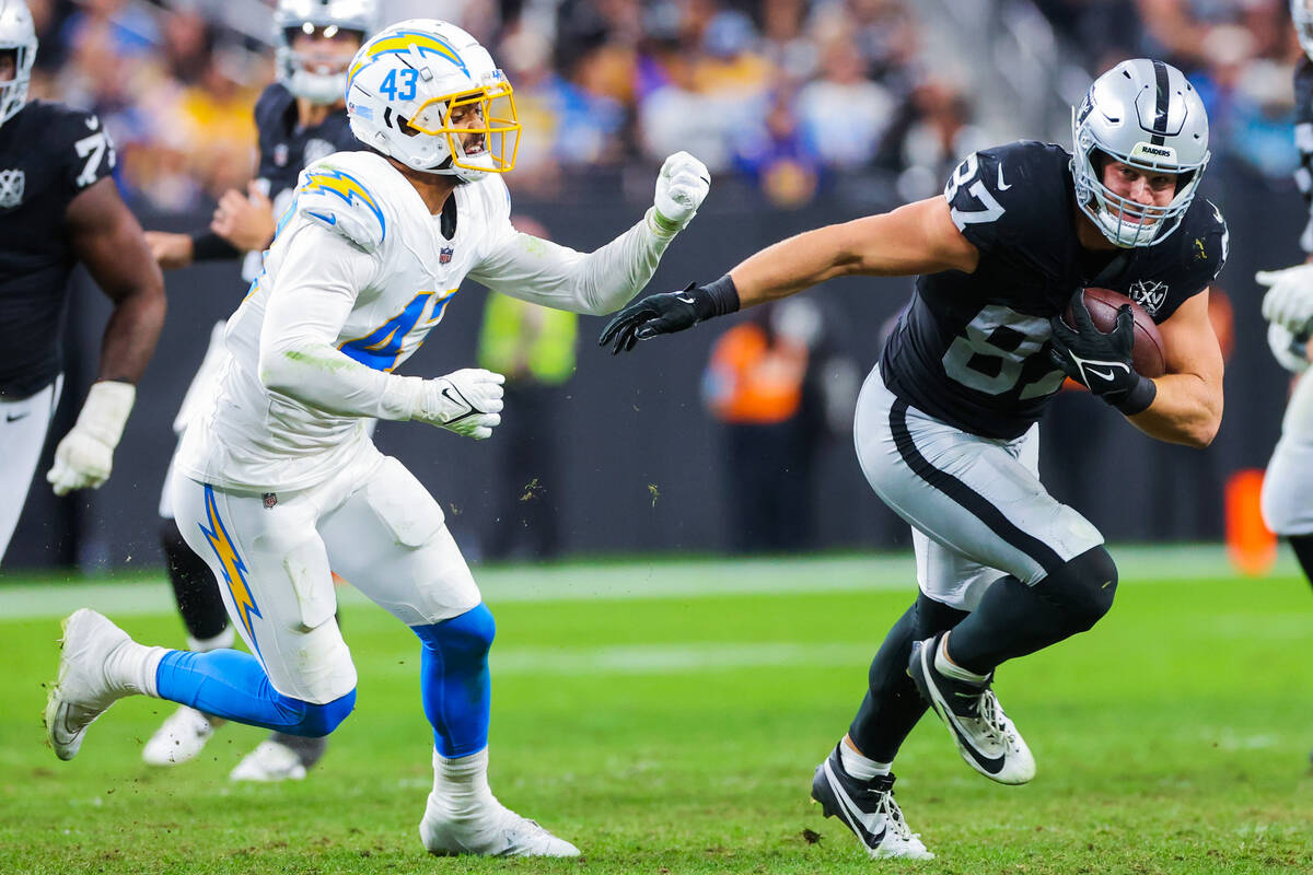 Raiders tight end Michael Mayer (87) hustles the ball as Los Angeles Chargers linebacker Troy D ...