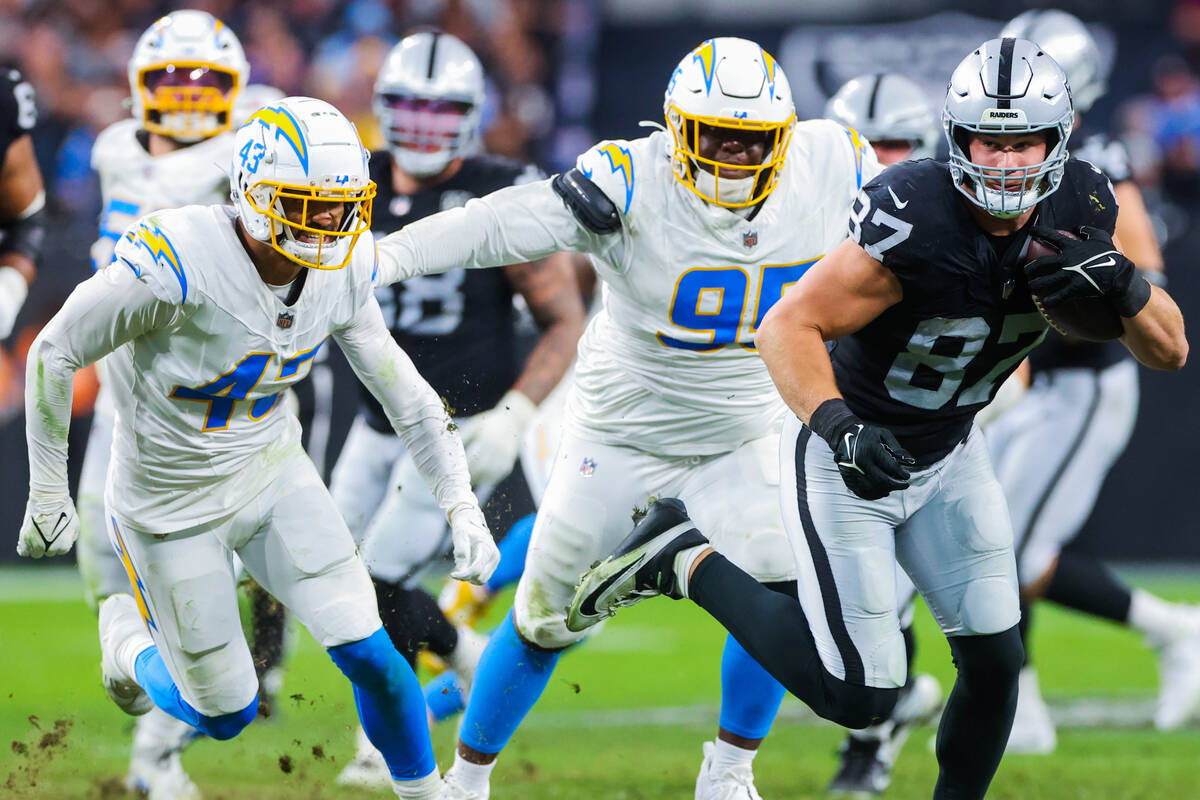 Raiders tight end Michael Mayer (87) hustles the ball as Los Angeles Chargers linebacker Troy D ...