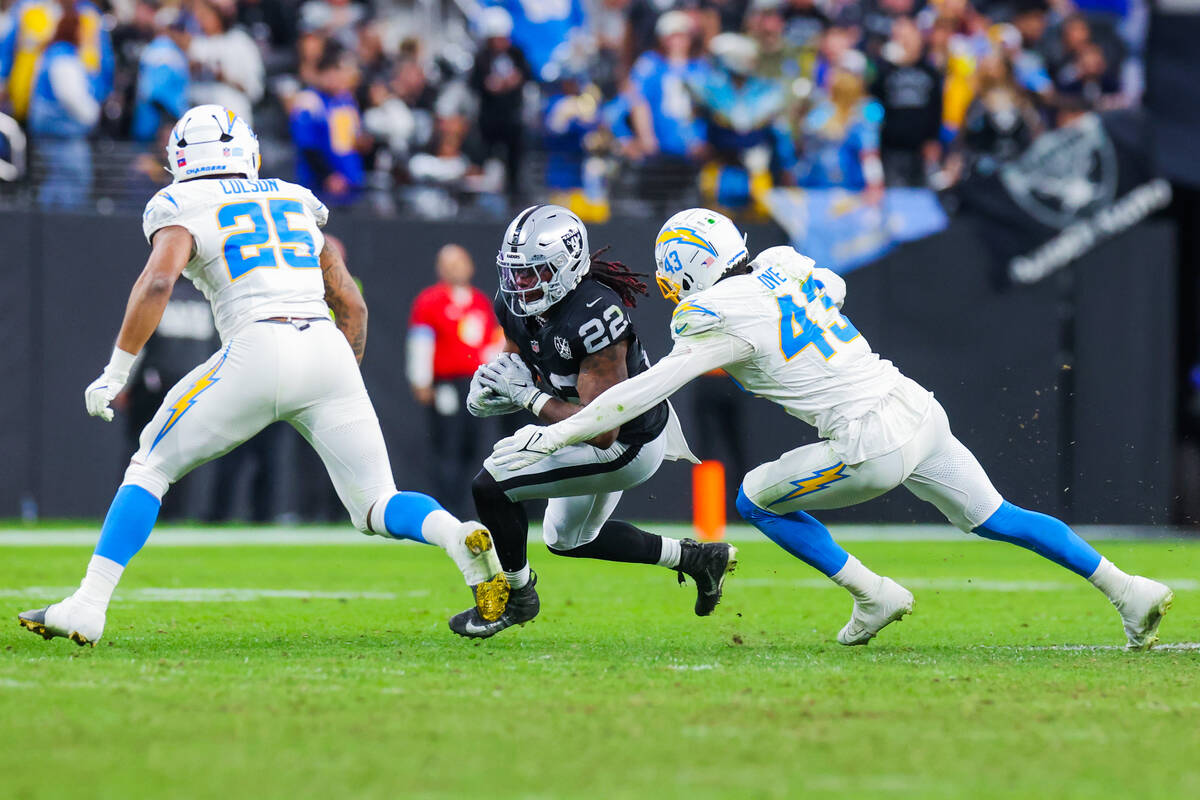 Raiders running back Alexander Mattison (22) runs the ball as Los Angeles Chargers linebacker T ...