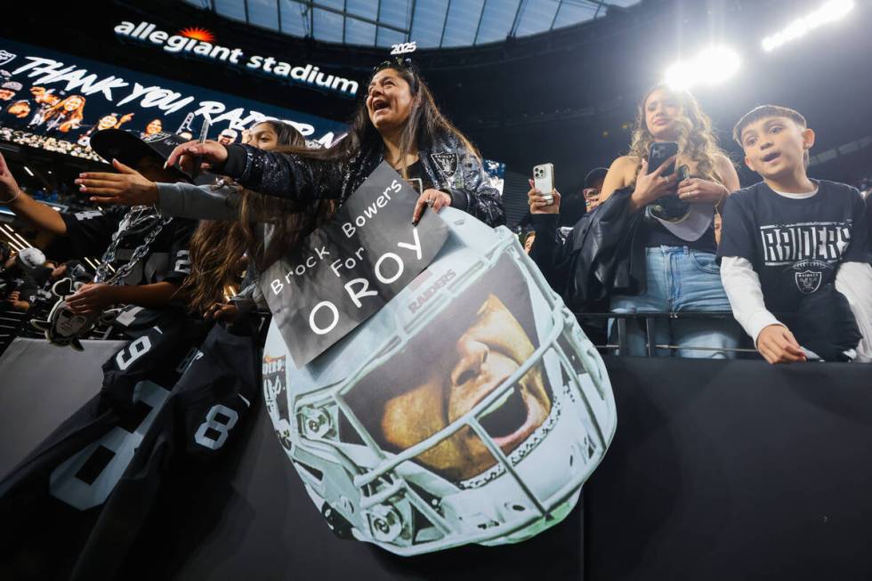 Raiders fans cheer for autographs from players after an NFL football game between the Raiders a ...