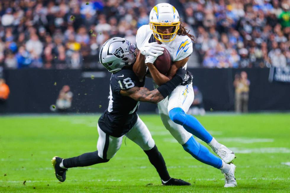 Los Angeles Chargers wide receiver Quentin Johnston (1) runs the ball as Raiders cornerback Jac ...