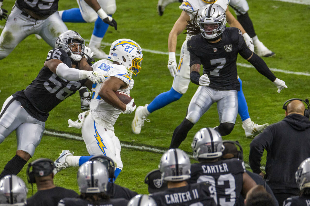 Raiders linebacker Amari Burney (56) tackles Los Angeles Chargers running back J.K. Dobbins (27 ...