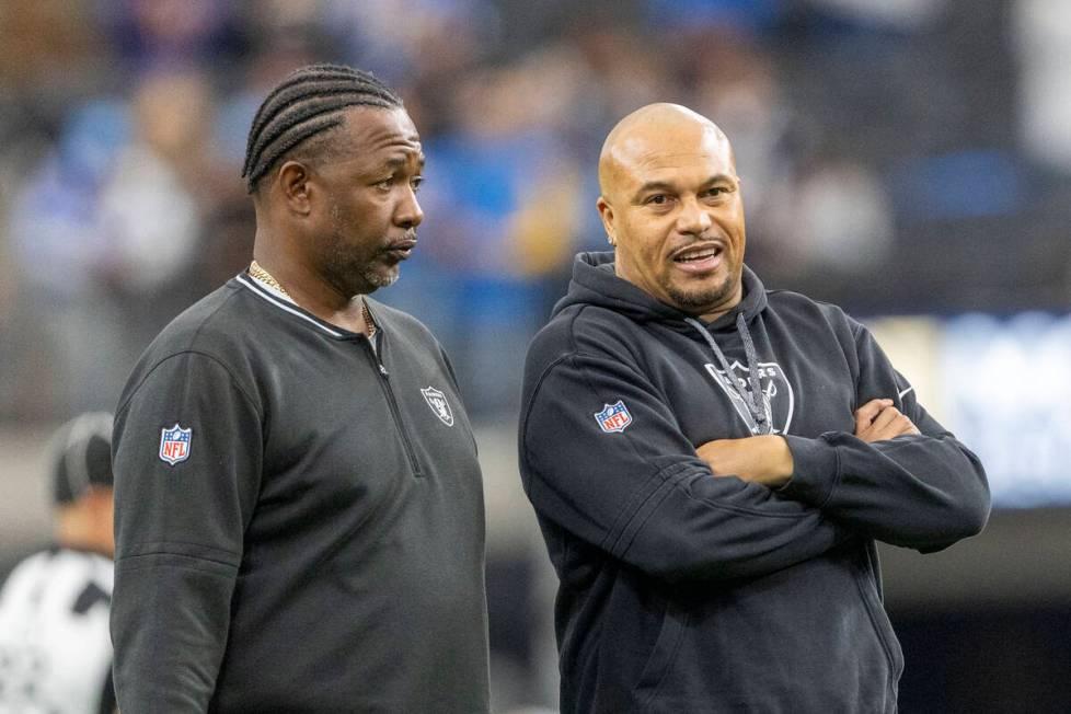 Raiders defensive coordinator Patrick Graham, left, listens to head coach Antonio Pierce before ...