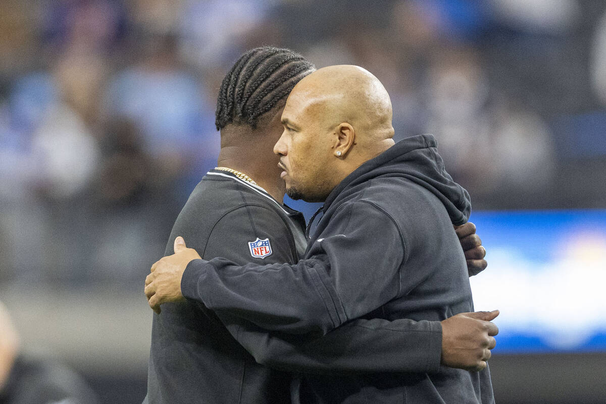 Raiders head coach Antonio Pierce, right, and defensive coordinator Patrick Graham hug before a ...