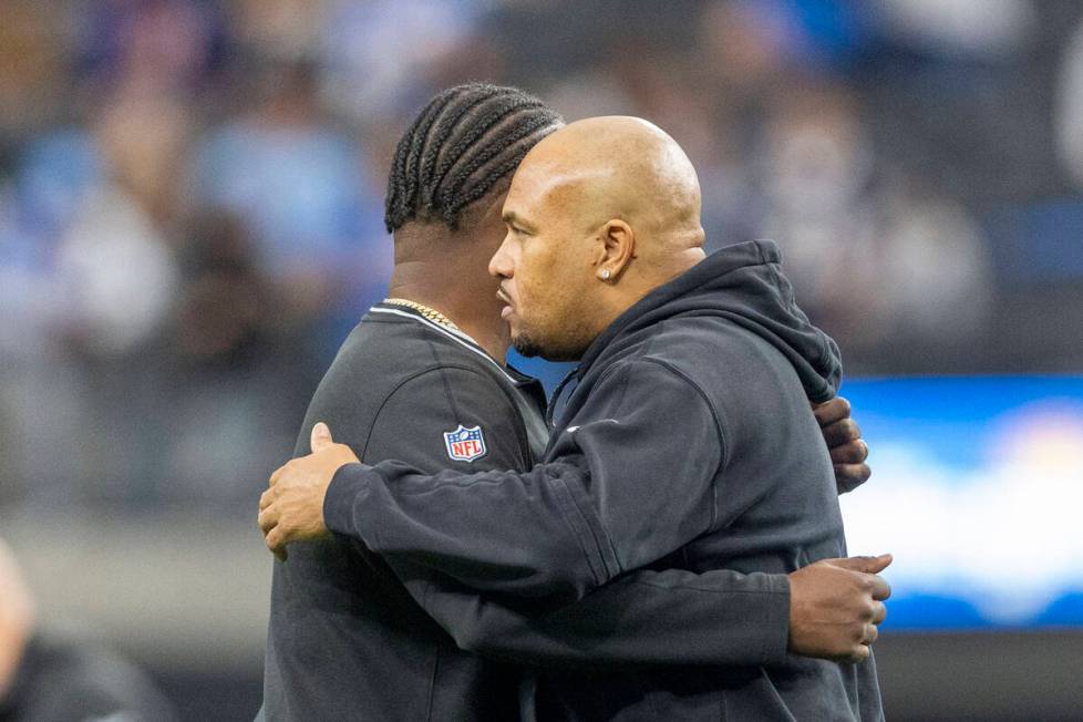 Raiders head coach Antonio Pierce, right, and defensive coordinator Patrick Graham hug before a ...