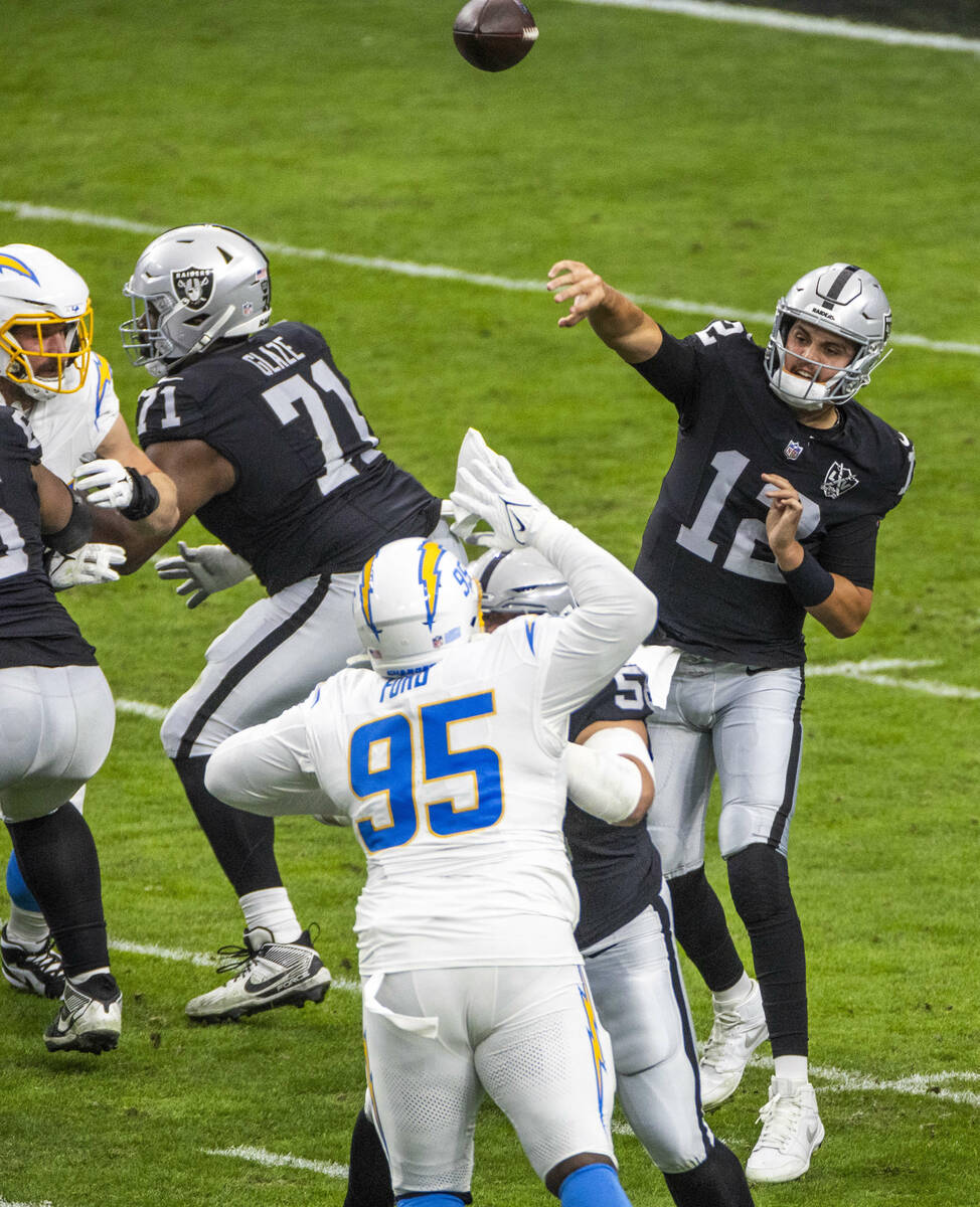 Raiders quarterback Aidan O'Connell (12) gets off a pass against the Los Angeles Chargers durin ...