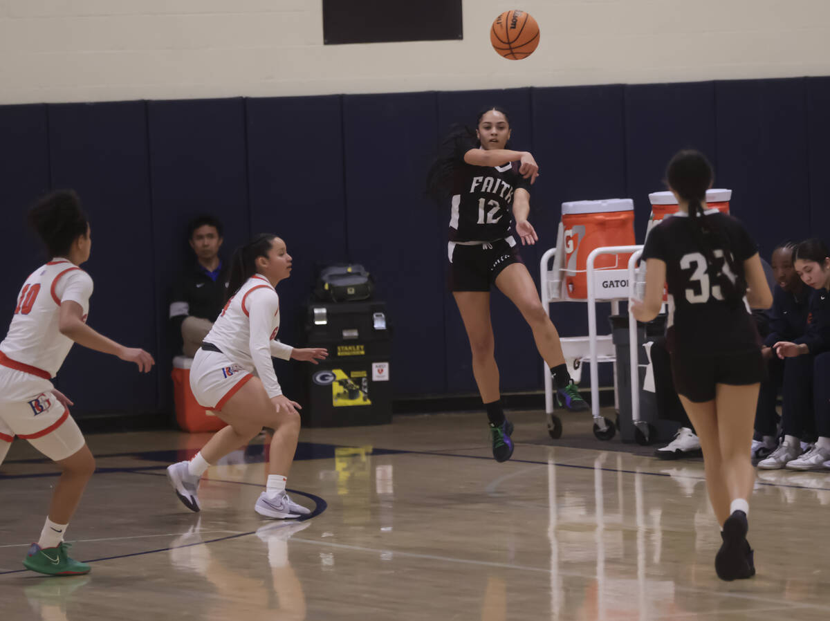 Faith Lutheran's Aliyah Maese (12) throws a pass to Emma Herpin (33) during a high school baske ...