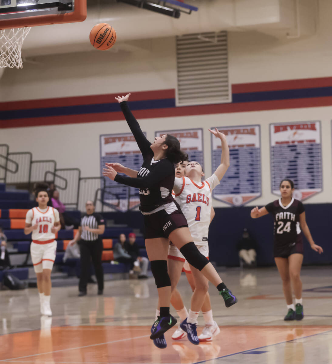 Faith Lutheran's London Camacho (23) lays up the ball past Bishop Gorman's Baylee Holton (1) du ...