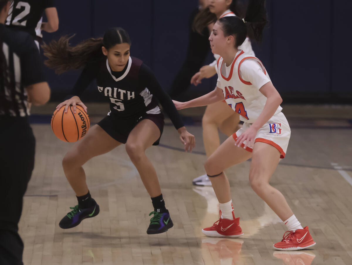 Faith Lutheran's Caylyn Young (5) drives the ball against Bishop Gorman's Kenzee Holton (14) du ...