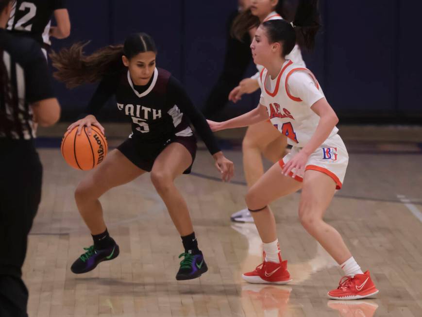 Faith Lutheran's Caylyn Young (5) drives the ball against Bishop Gorman's Kenzee Holton (14) du ...