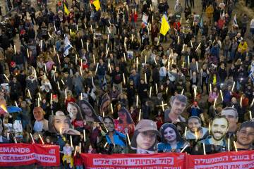 Protesters hold photos of hostages held in the Gaza Strip and 100 light sticks to symbolize 100 ...