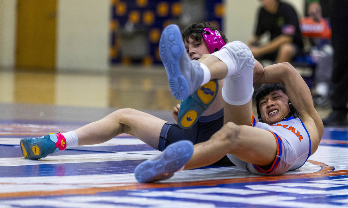 SLAM's Eric Bice, left, fights for control on the mat with Bishop Gorman's Elijah Tabasa during ...